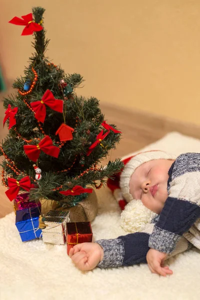 Małe Dziecko Kapeluszu Mikołaja Śpiące Pod Choinką Prezentami — Zdjęcie stockowe