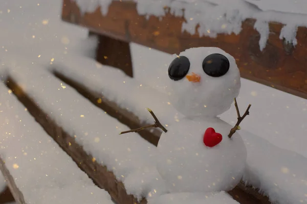 Маленький Снеговик Красным Сердцем Снежной Скамейке — стоковое фото