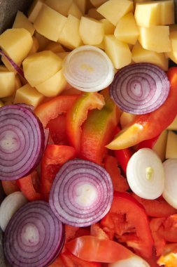 Pişirmek için pişirilmiş çiğ sebzeler: Patates, soğan, yakın plan biber..