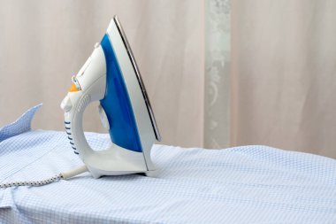 Bir ütü, ütü masasında bir gömlek