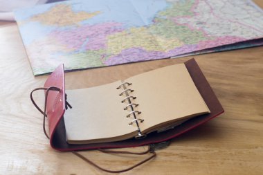 Gezgin eşyaları, harita ve defter ahşap bir arka planda.