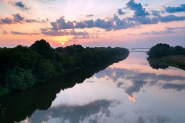 Gün doğumunda gökyüzü ve güneş nehirde.