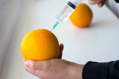 El yapımı fotoğraf açık arkaplanda bir portakala enjekte