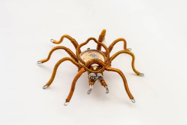 Beyaz arkaplanda saat mekanizması olan metal örümcek, steampunk tarzı, yakın plan.
