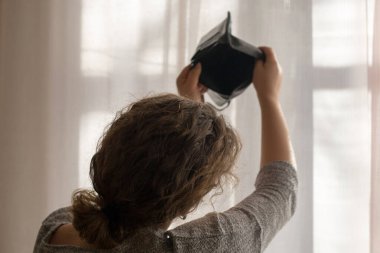 Genç bir kızın elinde boş siyah cüzdan, yoksulluk teması