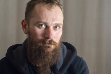 Uzun sakallı, ciddi, beyaz bir adamın portresi.