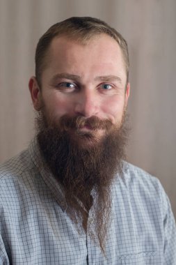 Uzun sakallı, gülümseyen beyaz bir adamın portresi.