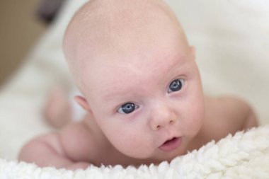 Karnının üzerinde yatan şirin bir bebeğin portresi.