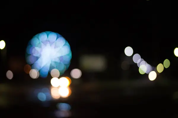 夜の街の観覧車やライトは 明るい背景をぼやけて — ストック写真