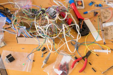 Masaüstünde elektronikle çalışmak için farklı elektrik kabloları ve diğer araçlar