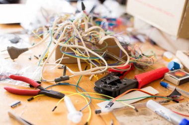 Masaüstünde elektronikle çalışmak için farklı elektrik kabloları ve diğer araçlar