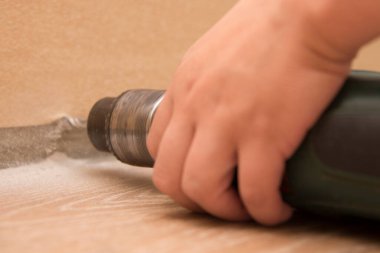 El matkabı duvarın yanında tutuyor, yakın plan, tamir işi ve bina teması.