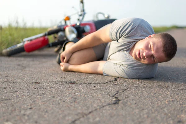 Bir Adam Dizine Tutunur Motosikletinin Yanındaki Asfaltta Yatar Trafik Kazalarının — Stok fotoğraf
