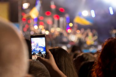 İnsanlar akıllı telefonları tutar ve gece fotoğraflarını çekerler.