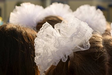 Okullu bir kızın saçında güzel beyaz fiyonklar