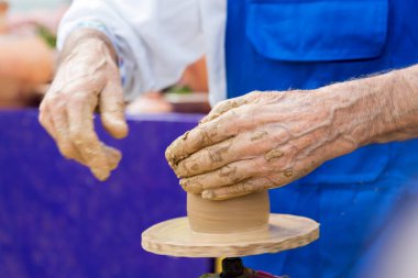 Yaşlı bir adam kilden sürahi yapar, yakın plan.