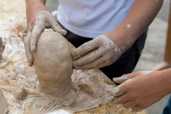 Eller insanın kafasını kilden yapar, yakın plan.