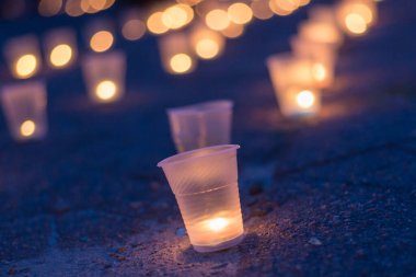 Sokakta asfaltta yanan bir grup mum. Yakınını kaybedenler için anma günü