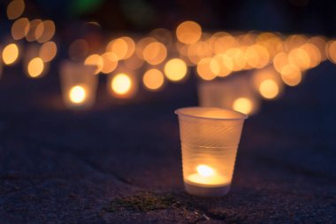 Sokakta asfaltta yanan bir grup mum. Yakınını kaybedenler için anma günü