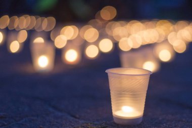 Sokakta asfaltta yanan bir grup mum. Yakınını kaybedenler için anma günü