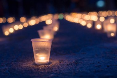 Sokakta asfaltta yanan bir grup mum. Yakınını kaybedenler için anma günü