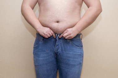 Kot pantolon giyen bir adam, şişman bir göbek, aşırı kilolu olma sorunu.