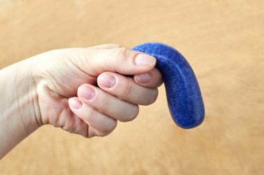 A toy made of soft plasticine in the hand of a woman, the theme of sexual dysfunctions, the toy symbolizes the penis