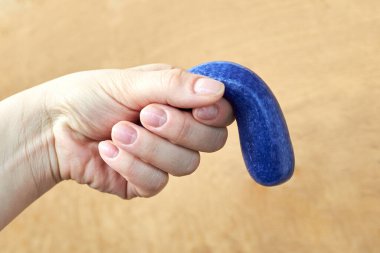 A toy made of soft plasticine in the hand of a woman, the theme of sexual dysfunctions, the toy symbolizes the penis clipart