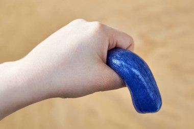 A toy made of soft plasticine in the hand of a woman, the theme of sexual dysfunctions, the toy symbolizes the penis