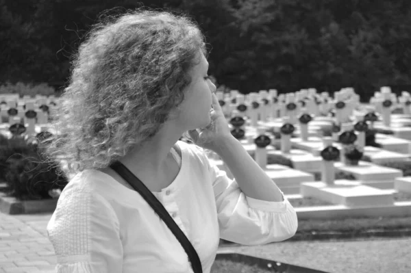 孤独な女が墓地の墓の数多くを歩く 黒と白の写真 — ストック写真