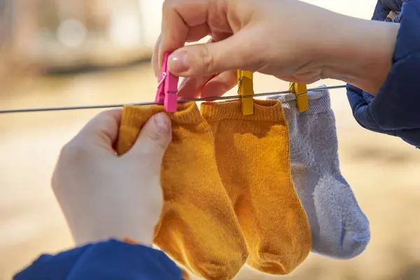 Moeder Hangt Kleine Baby Sokken Een Waslijn Voor Het Drogen — Stockfoto