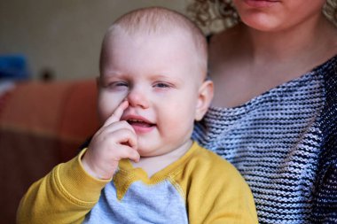 Parmağını burnuna sokmuş komik şirin bir çocuk.