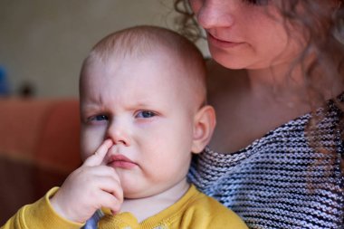 Parmağını burnuna sokmuş komik şirin bir çocuk.