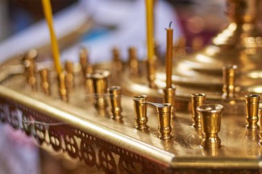 Ortodoks Kilisesi 'ndeki büyük altın bir avizede mumlar, yakın plan.