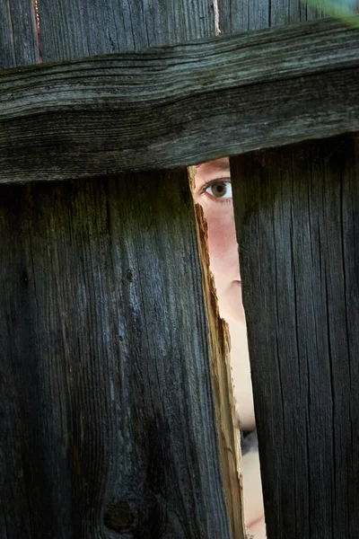 Μια Γυναίκα Κατασκοπεύει Μέσα Από Ρωγμή Ενός Ξύλινου Φράχτη Γείτονες — Φωτογραφία Αρχείου