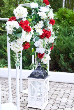 Güzel açık hava düğün süsleri, kırmızı ve beyaz çiçeklerle süslenmiş kemer, fenerler..