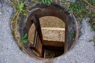 Yuvarlak kapak ve demir merdiven köprüden inmek için..