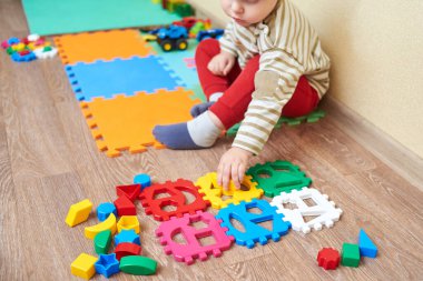 Çocuk figürleri renkli bir bloğa koyuyor, çocuklar için eğitici oyuncaklar..