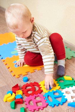 Çocuk figürleri renkli bir bloğa koyuyor, çocuklar için eğitici oyuncaklar..