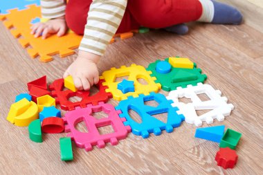 Çocuk figürleri renkli bir bloğa koyuyor, çocuklar için eğitici oyuncaklar..