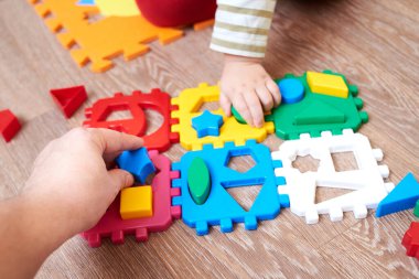 Baba çocuğa katlama oyuncakları ve çocuklar için eğitici oyunlar için bir figür veriyor..