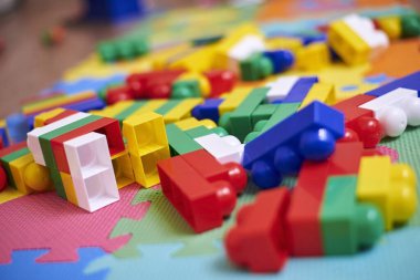 Renkli bir inşaat seti, bir evin zemininde, yakın plan. Çocuklar için eğitici oyunlar.