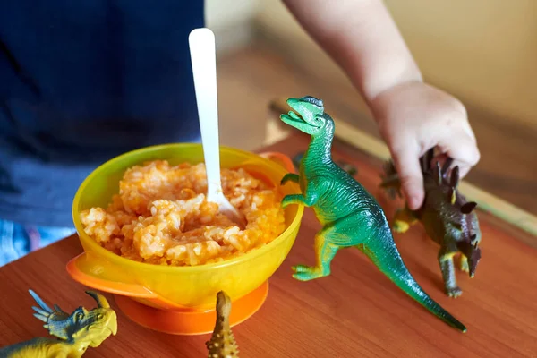 Dinosauri Giocattolo Stanno Tavolo Bambini Vicino Piatto Porridge Con Cucchiaio — Foto Stock
