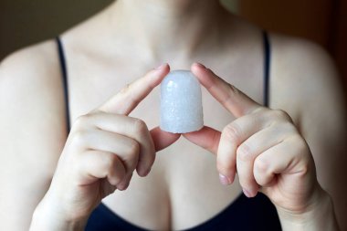 Doğal bir deodorant tutan bir kadın - alunit kristal, doğal ve tedavi edici kozmetik.