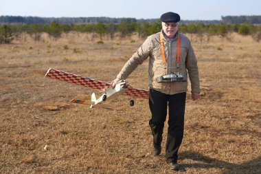 Yaşlı adam kazadan sonra RC uçağını kırık bir pervaneyle tutuyor..