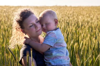 Annem yazın küçük oğlunu buğday tarlasında kucaklıyor, doğanın keyfi için..