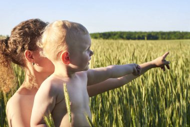 Anne oğlunu yazın bir buğday tarlasında tutuyor, doğanın keyfi için..