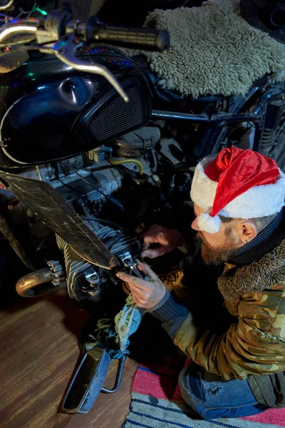 Homme Chapeau Père Noël Répare Une Vieille Moto Dans Garage — Photo