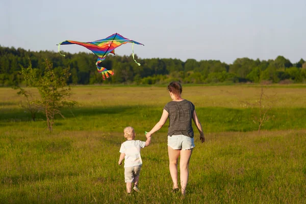 Mamá Con Hijo Pequeño Volar Una Cometa Prado Vista Trasera — Foto de Stock