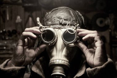 Solunum cihazı ve steampunk tarzı gözlüklü bir adam, palto giymiş, post tapokalipsis konsepti.